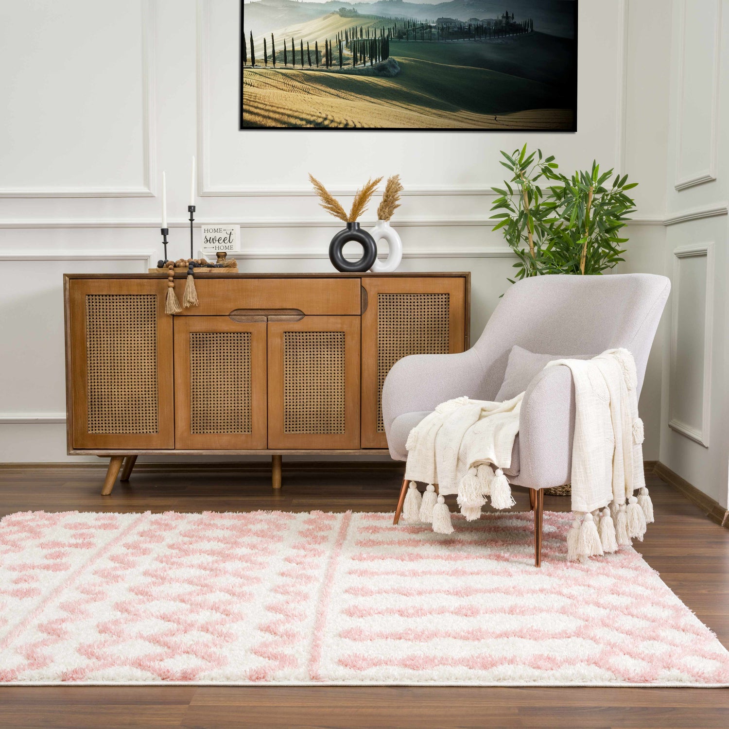 Living room scene with a Darva Pink Plush Area Carpet, wood cabinet, gray chair, and Tuscan landscape art. Roomscene-Rectangle