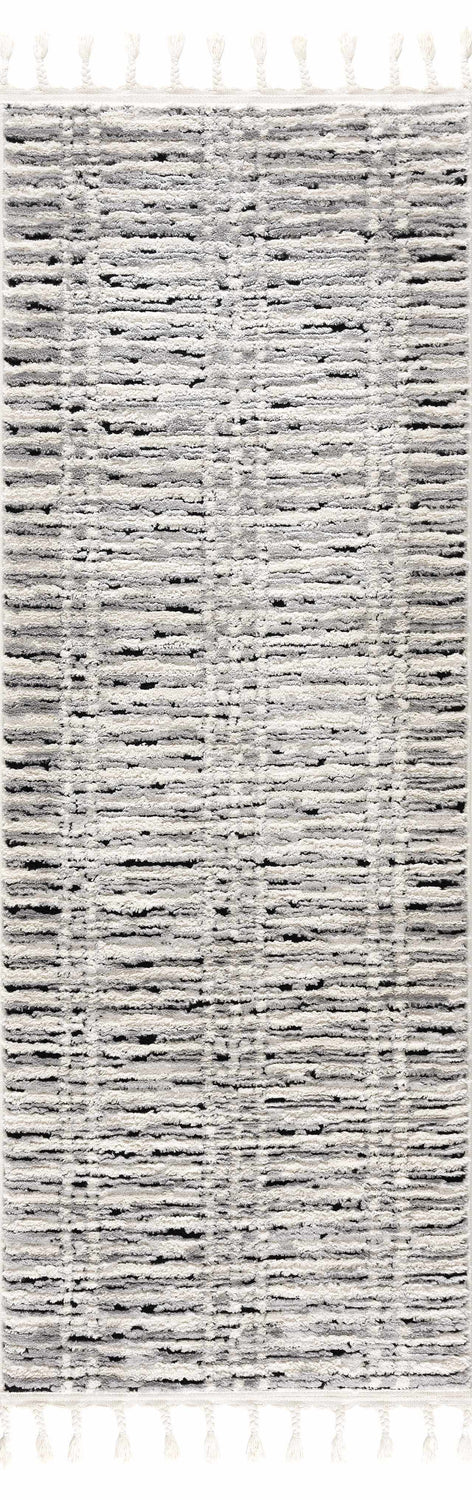 Close-up of the Nava Area Rug. Beige, bone, and black geometric pattern. Tassels on the ends. Design-Runner