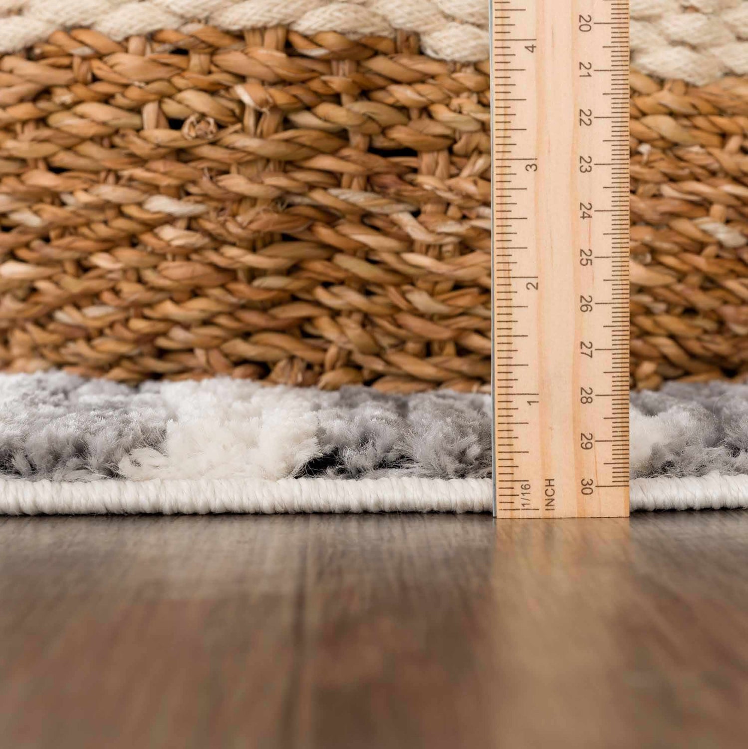 Close-up of the Nava Area Rug showing its pile height, beige and black geometric pattern, and woven texture. Pile