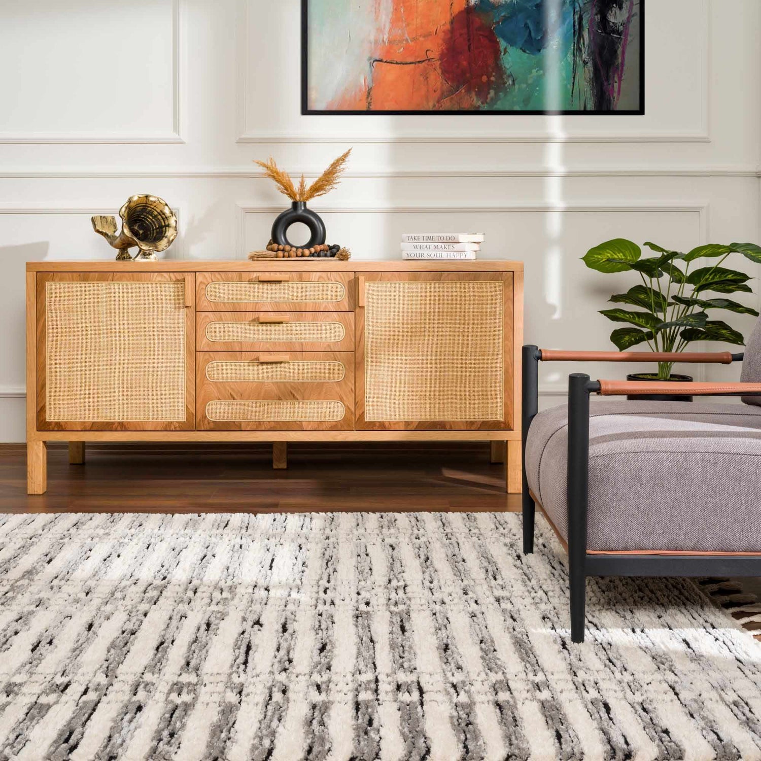 Living room scene with a beige and black Nava Area Rug, wood console table, and gray armchair. Roomscene-Rectangle