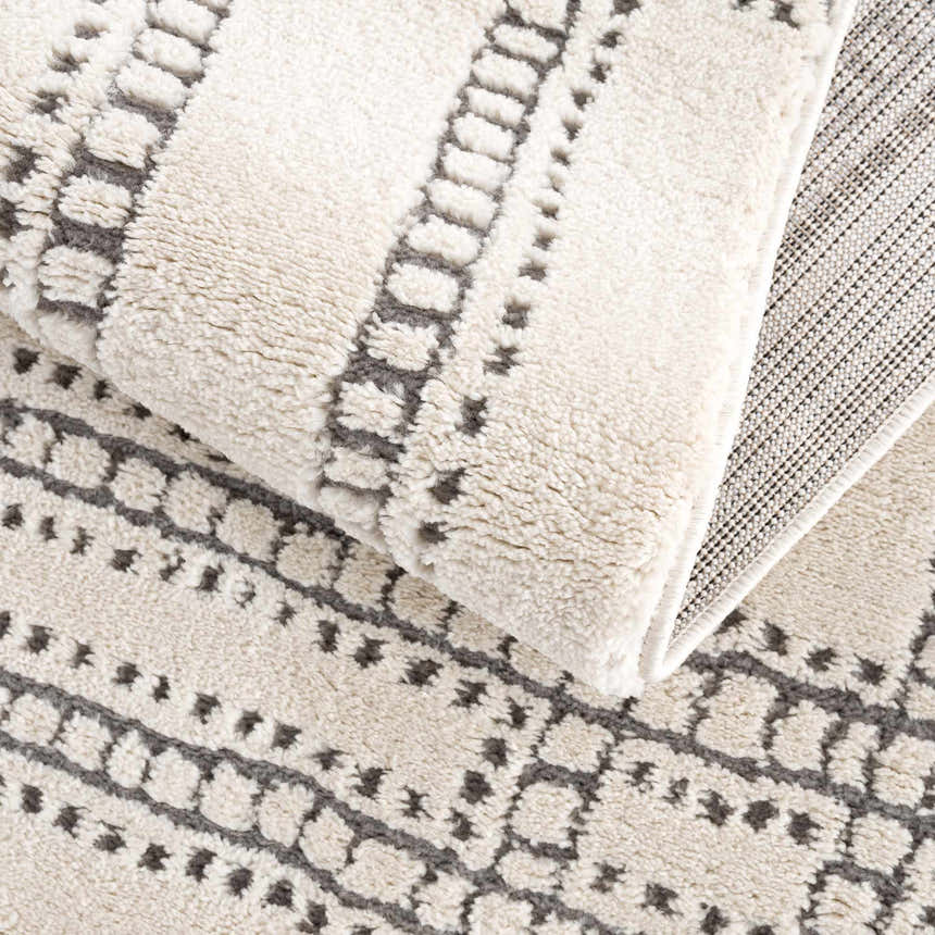 Close-up of Ryuu Ivory & Gray Area Rug showing the plush pile, geometric pattern, and durable backing. Fold