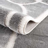 Close-up of the Azana Modern Gray Area Rug showing its geometric pattern, soft texture, and durable machine-woven construction. Fold