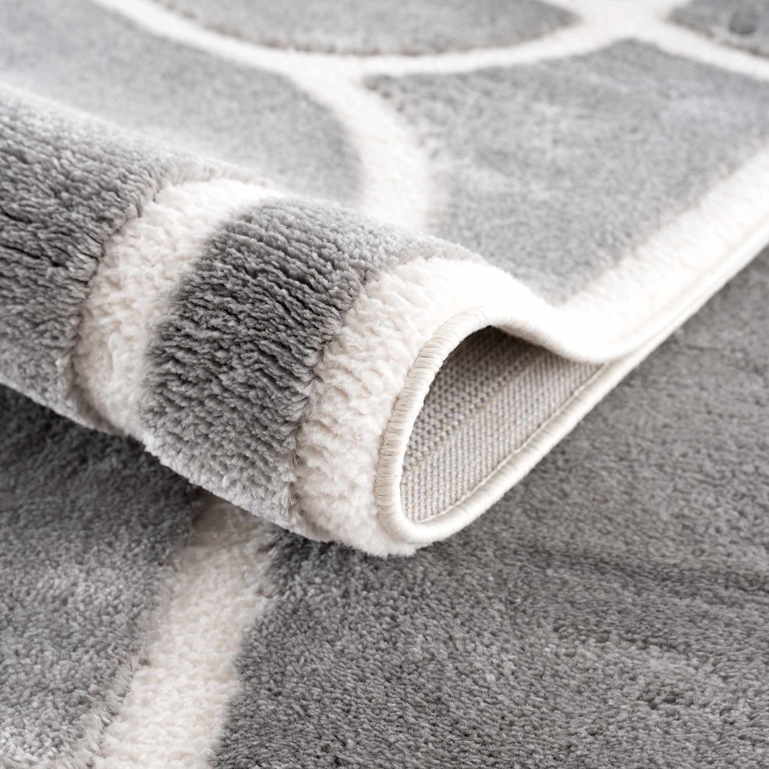 Close-up of the Azana Modern Gray Area Rug showing its geometric pattern, soft texture, and durable machine-woven construction. Fold