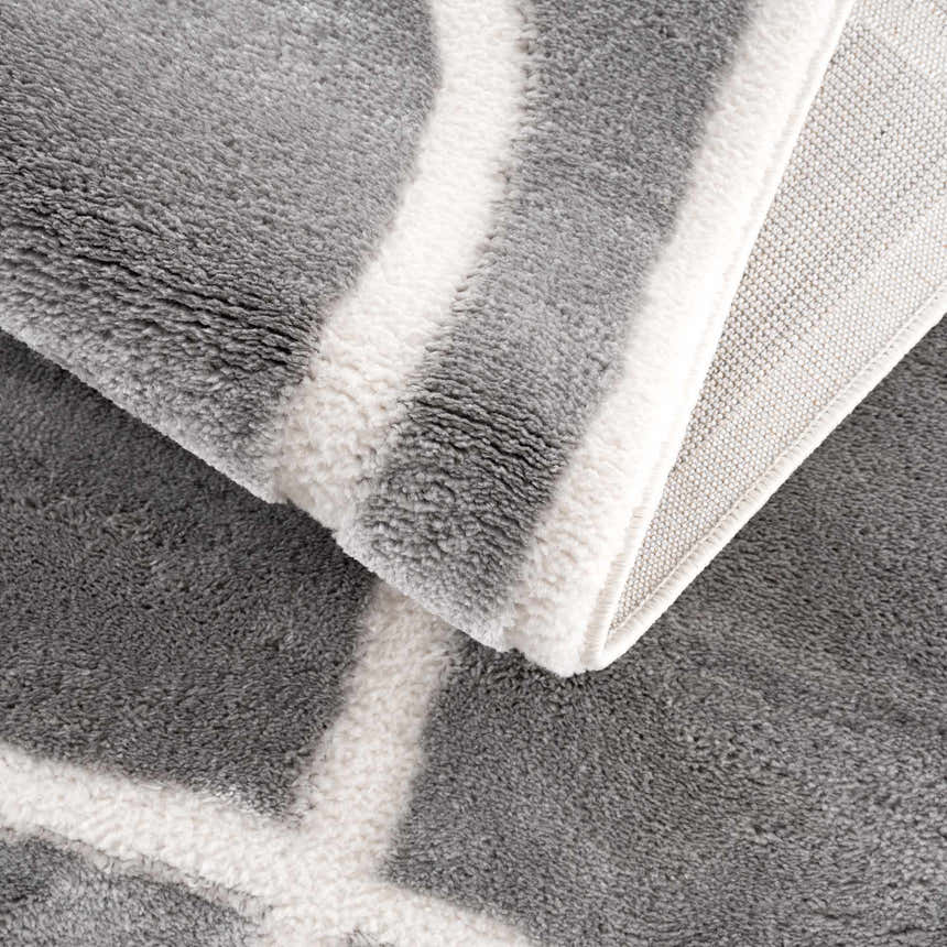 Close-up of the Azana Modern Gray Area Rug showing its geometric pattern, soft texture, and cream and gray colors. Fold