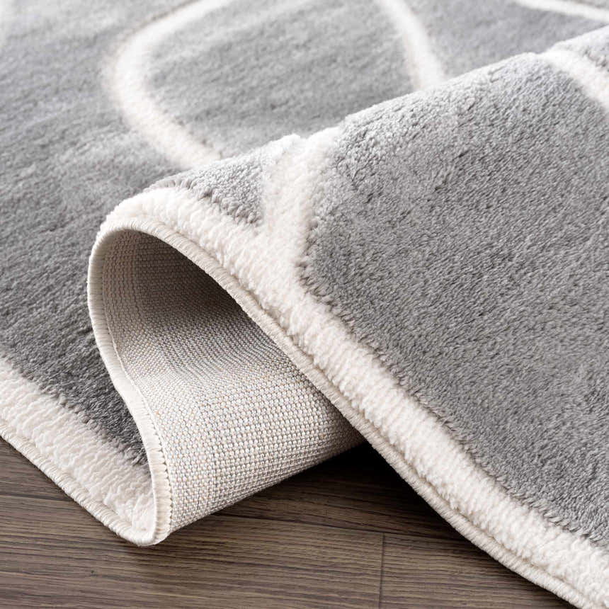 Close-up of the Azana Modern Gray Area Rug showing its geometric design, soft texture, and woven backing. Fold