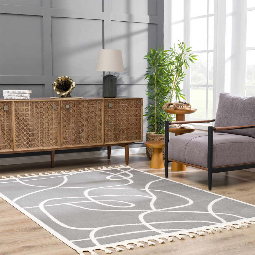 Living room scene with gray Azana Modern Gray Area Rug, wood cabinet, gray chair, and natural light. Roomscene-Rectangle