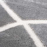 Close-up of the Azana Modern Gray Area Rug, featuring a geometric pattern in cream and gray polypropylene. Texture