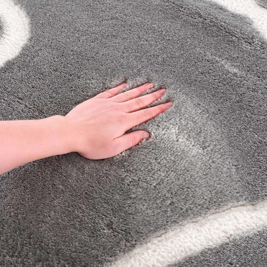 Close-up of the plush Azana Modern Gray Area Rug, showing its soft texture and cream geometric pattern. Texture