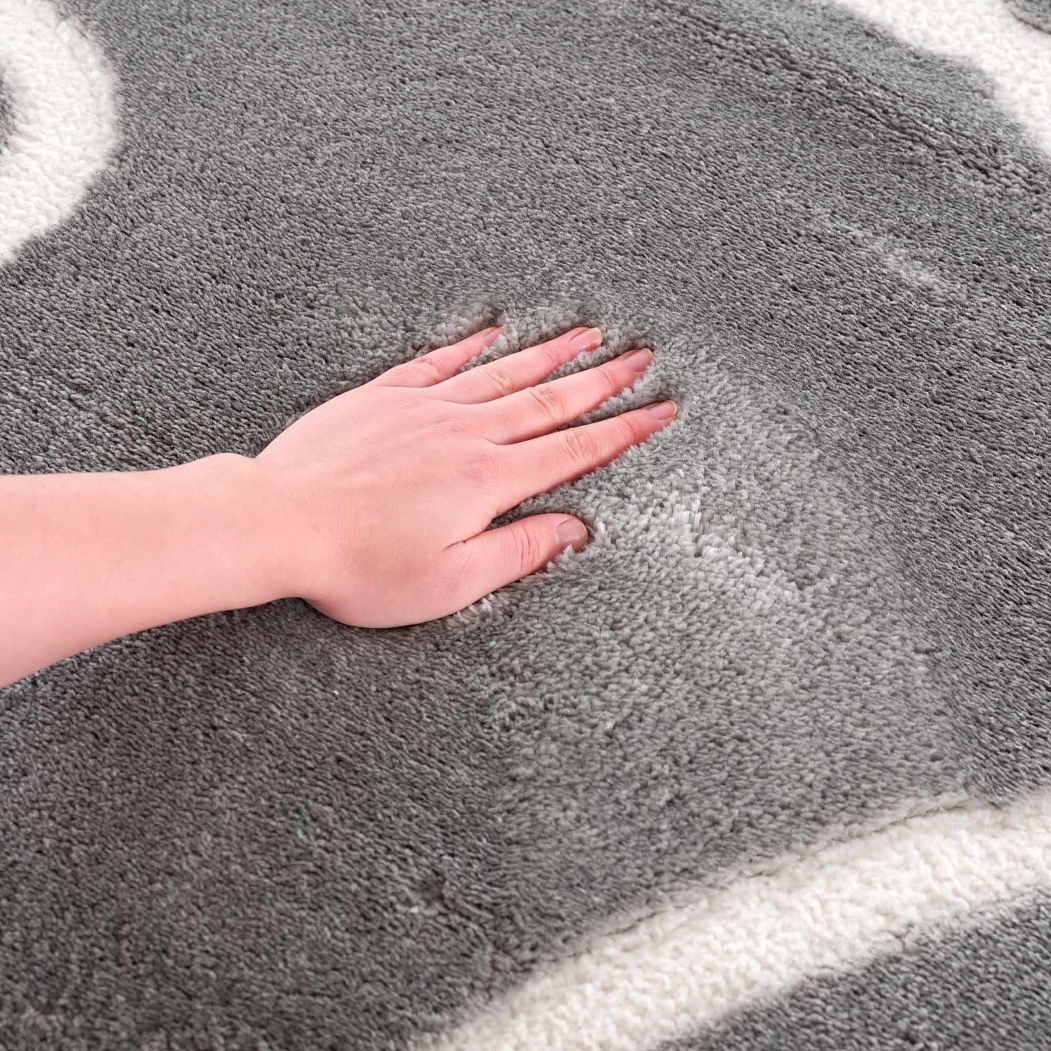 Close-up of the plush Azana Modern Gray Area Rug, showing its soft texture and cream geometric pattern. Texture