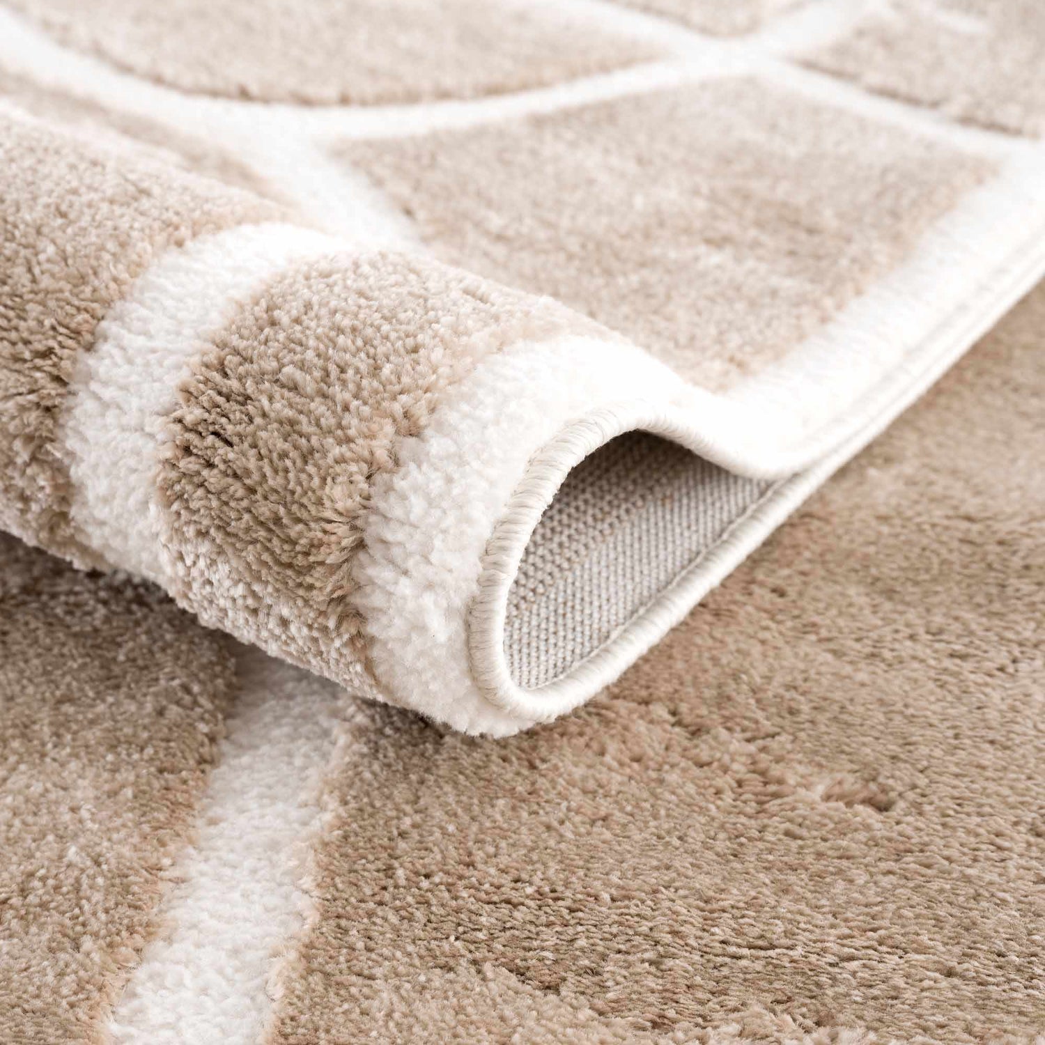Close-up of the plush Azana Cream Area Rug showing its geometric pattern and soft, textured pile. Fold