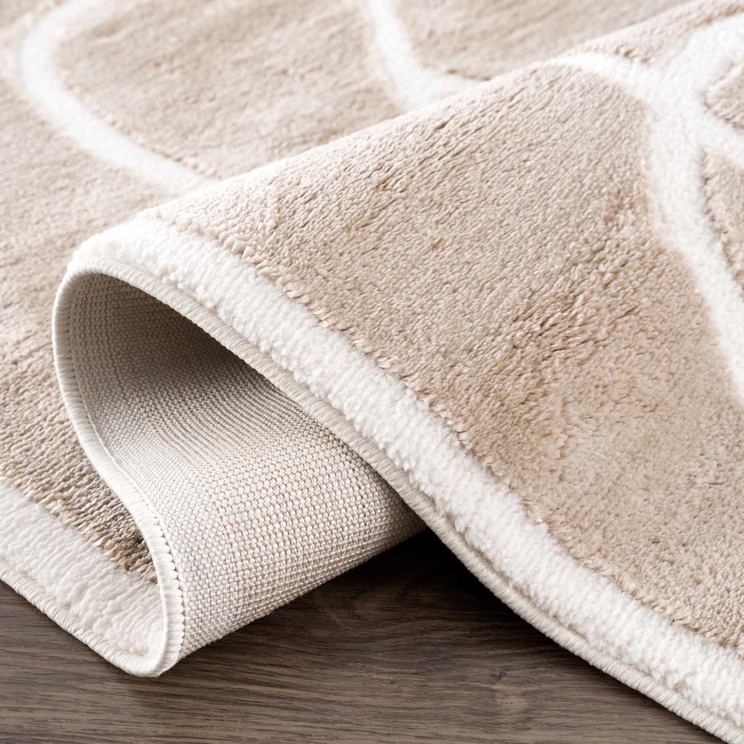 Close-up of the Azana Cream Area Rug showing its geometric pattern, plush texture, and durable backing. Fold