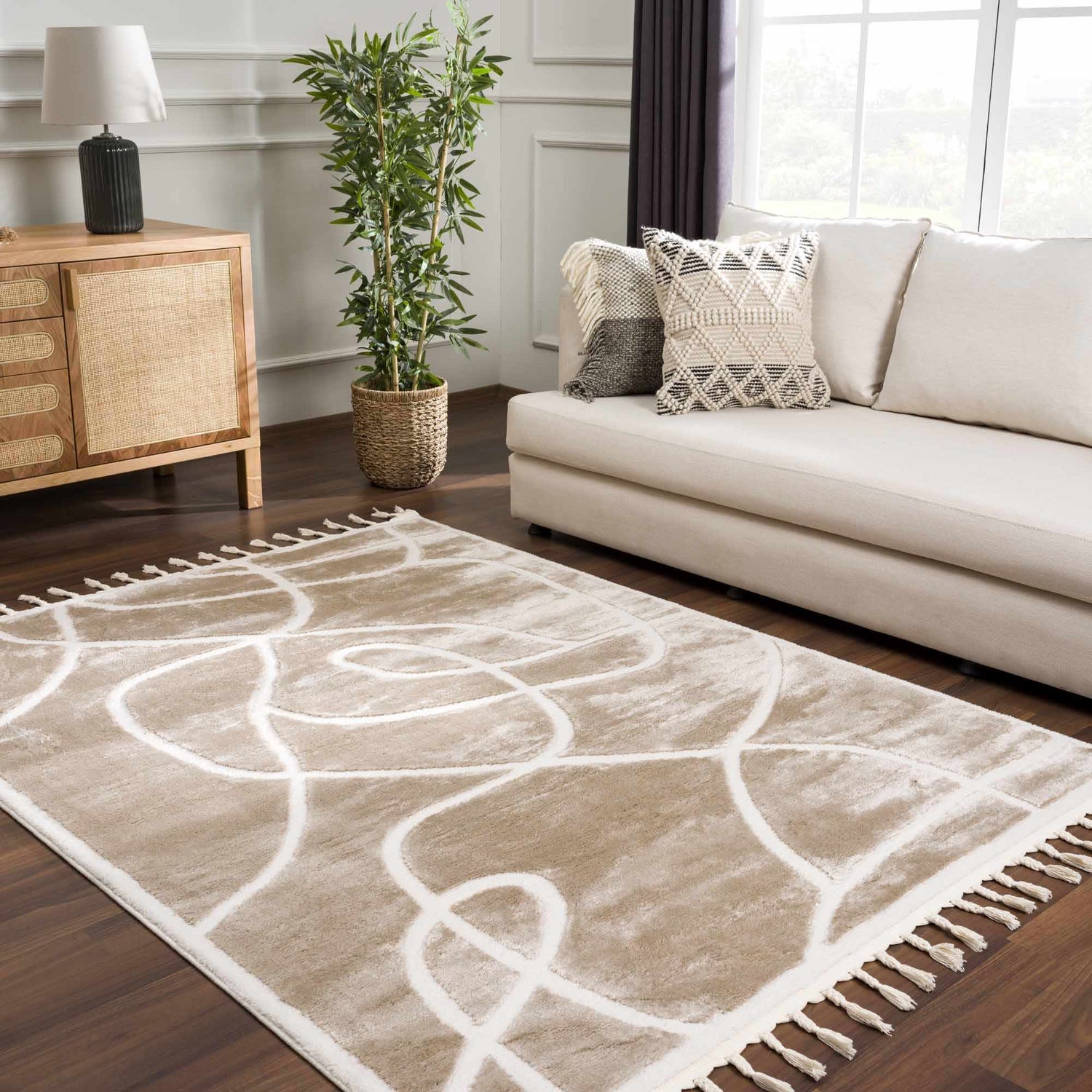 Living room scene with a cream sofa and the Azana Cream Area Rug with an abstract design and tassels. Roomscene-Rectangle