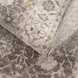 Close-up of the Amaru Green Textured Rug, showing the dusty sage, gray, and mustard floral pattern and soft, textured pile. Fold