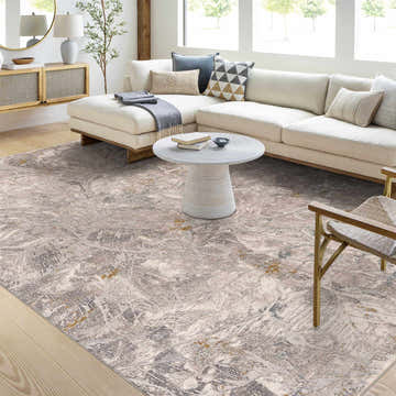 Living room scene with a Hinda Textured Rug in gray tones under a white sectional sofa and round coffee table. Roomscene-Rectangle