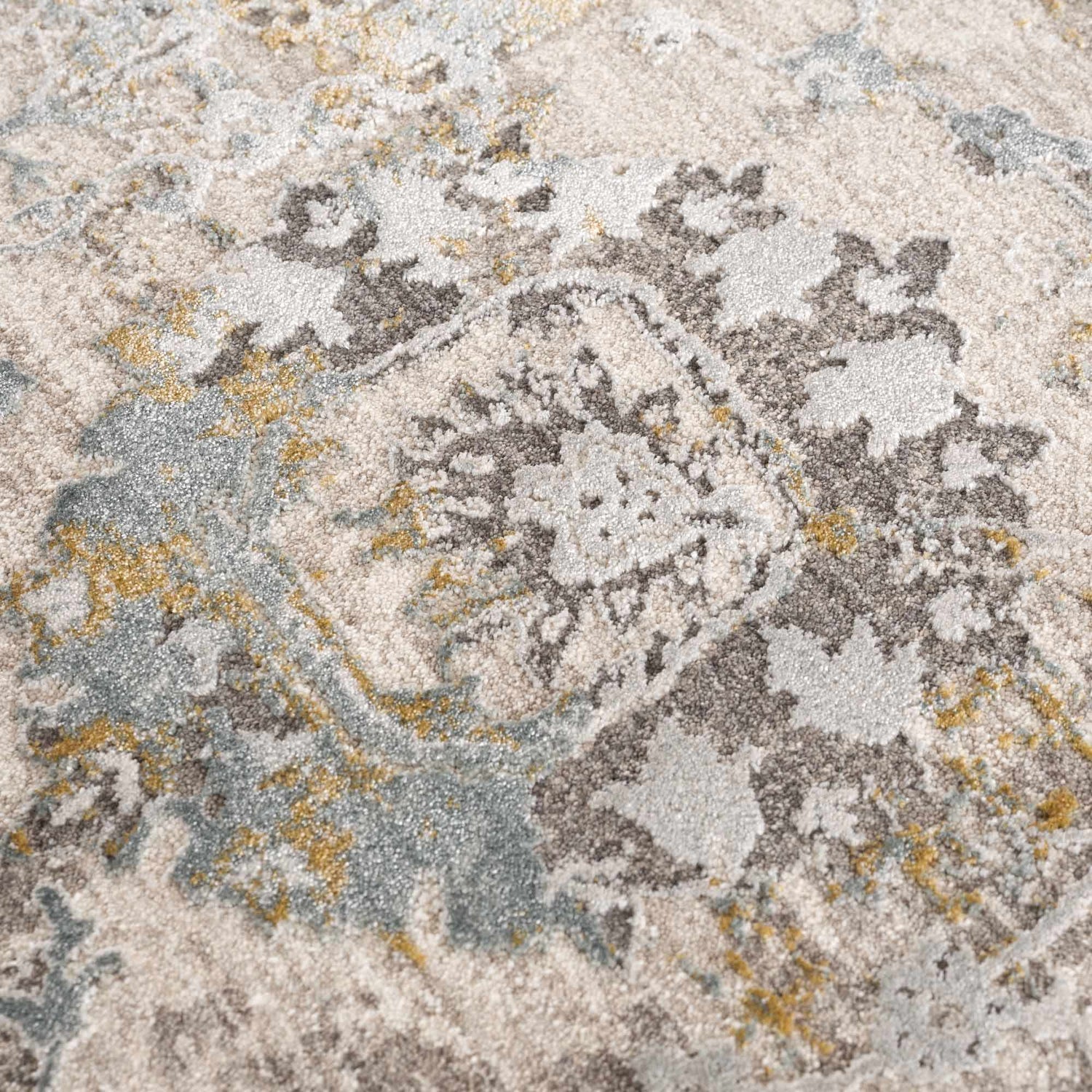 Close-up of the Alroy Textured Rug. Features a gray, brown, and natural abstract pattern with a soft, textured pile. Texture