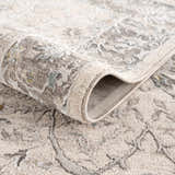 Close-up of the Gauge Cream & Gray Blue Rug showing its texture, neutral colors, and traditional pattern. Fold