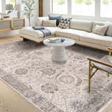 Living room with a Gauge Cream & Gray Blue Rug, white sofa, and round coffee table. Neutral tones create a calming space. Roomscene-Rectangle