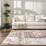 Living room with a Bindi Blue & Rose Area Rug, cream sofa, wood floors, and potted tree. Roomscene-Rectangle
