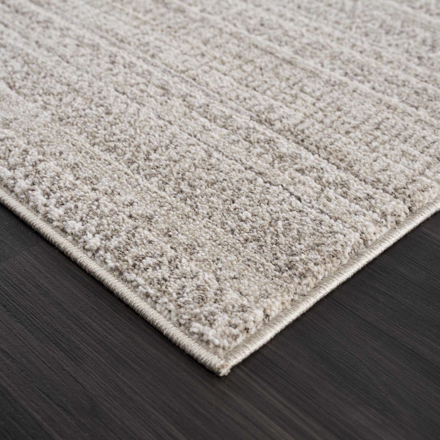 Close-up of the Nate Beige Tribal High Pile Carpet showing its soft texture and subtle linear design. Beige and ivory tones. Corner