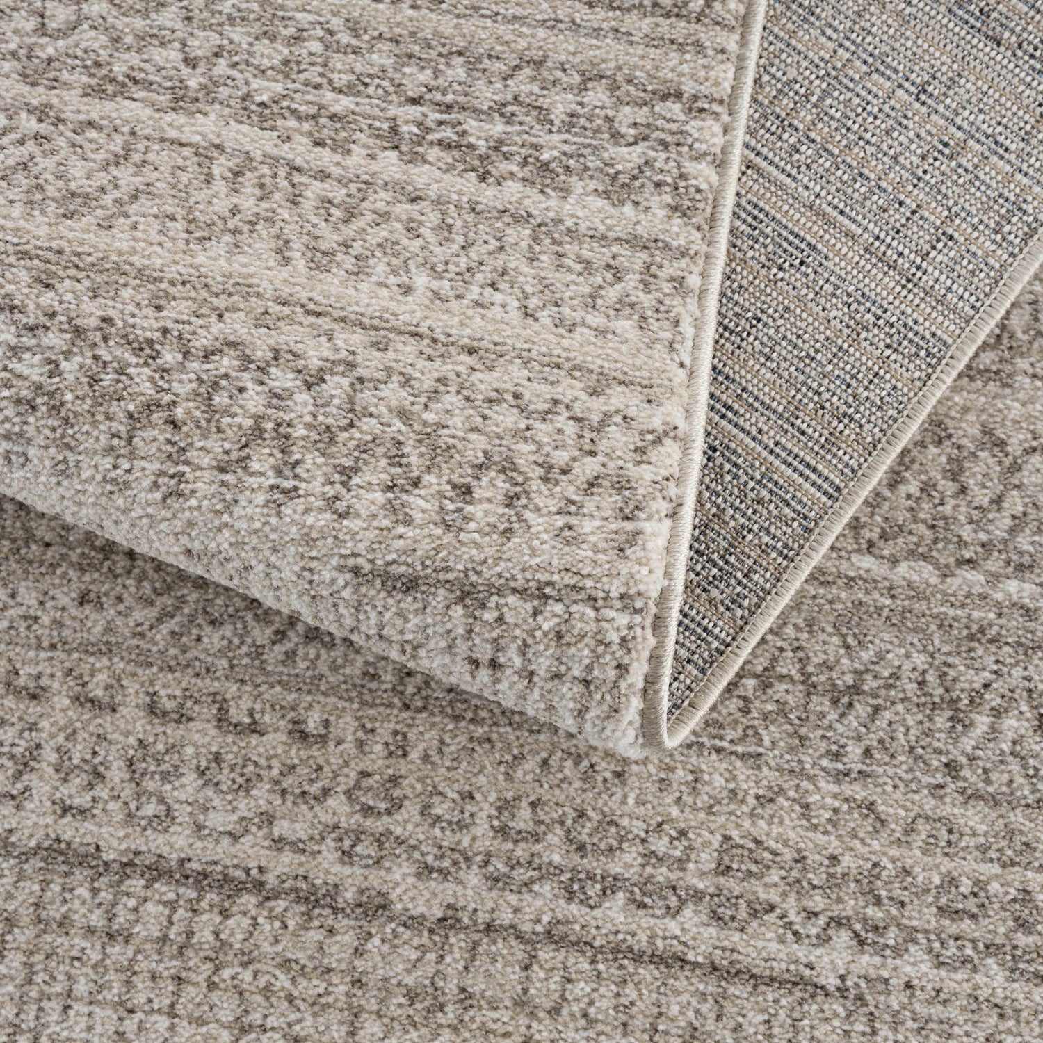 Close-up of the Nate Beige Tribal High Pile Carpet showing its neutral beige tones and high pile texture. Fold