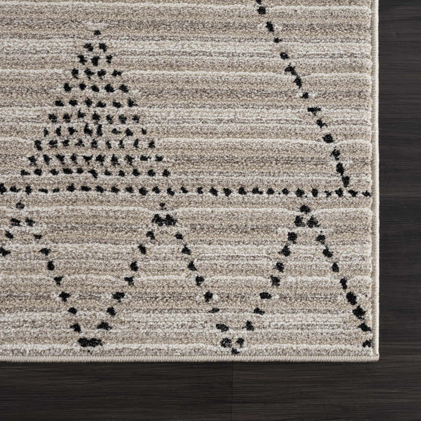 Close-up of the Lexi Area Rug: beige and ivory polyester with a black geometric dotted pattern. Machine woven texture. Swatch