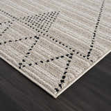 Close up of the beige and ivory Lexi Area Rug with a geometric dotted pattern. Corner