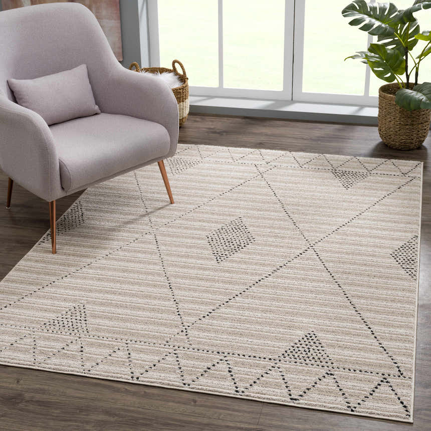 Living room scene with a beige Lexi Area Rug featuring a geometric design, paired with a lilac armchair. Roomscene-Rectangle