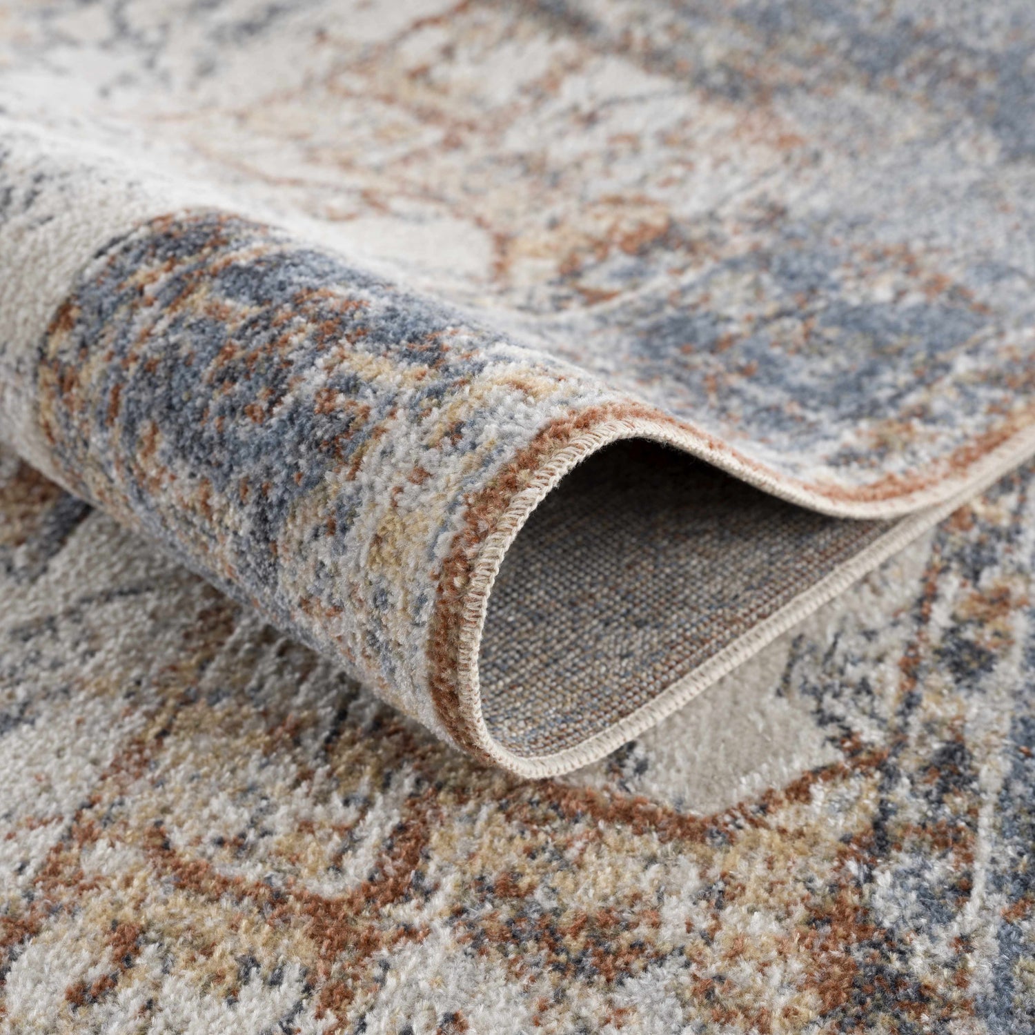 Close-up of the Blue Orange Hera Washable rug showing its traditional vintage pattern and texture. Corner