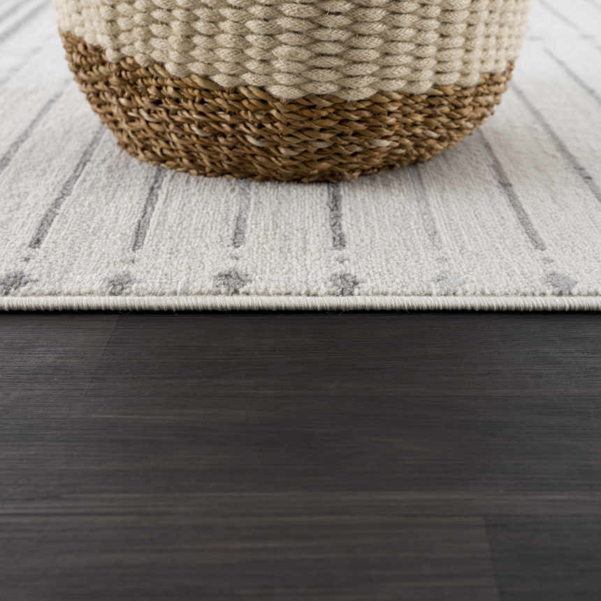 Close-up of Tigri Aztec Ivory & Gray rug with gray stripes and a basket on dark wood floors. Farmhouse style. Pile