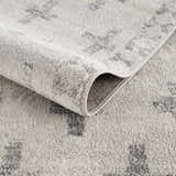 Close-up of the Tigris Swiss Cross Ivory&Gray Area Rug showing its geometric pattern and soft, textured polypropylene material. Fold