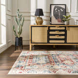 Living room scene with Bindi Blue & Rose Area Rug, wood floors, and a rattan cabinet with black accents. Roomscene-Rectangle