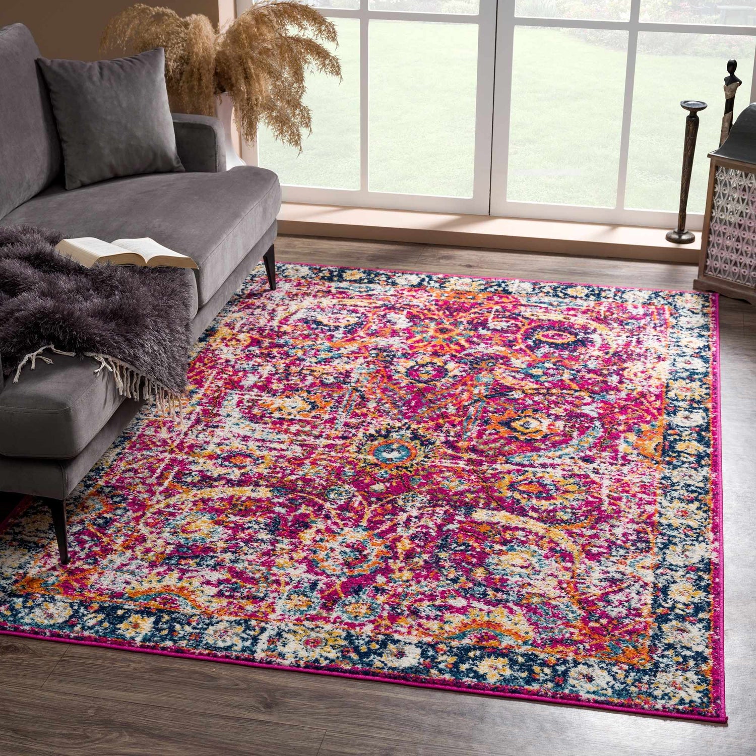 Living room scene with gray sofa and bright New Vick Area Rug in pink, orange, blue, and yellow. Roomscene-Rectangle