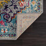 Close-up of New Delanson Area Rug showing floral pattern in gray, teal, yellow, and pink on dark wood floor. Fold