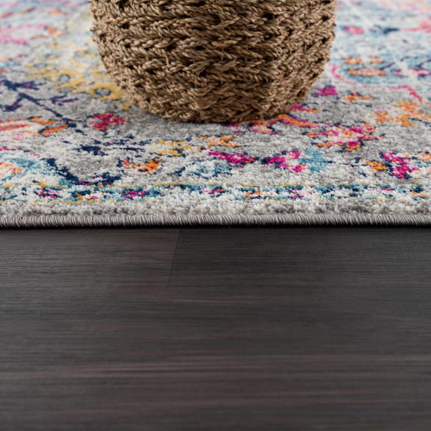 Close-up of the New Delanson Area Rug showing its gray, floral pattern with pink, blue, and yellow accents. Pile