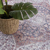 Close-up of the Red Cael Tumble Dry Washable Rug featuring a vintage Persian pattern in red, navy, and off-white colors. Styleshot