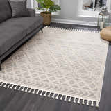 Living room scene with gray sofa and Magnolia Beige 2301 area rug featuring geometric pattern and tassels. Roomscene-Rectangle