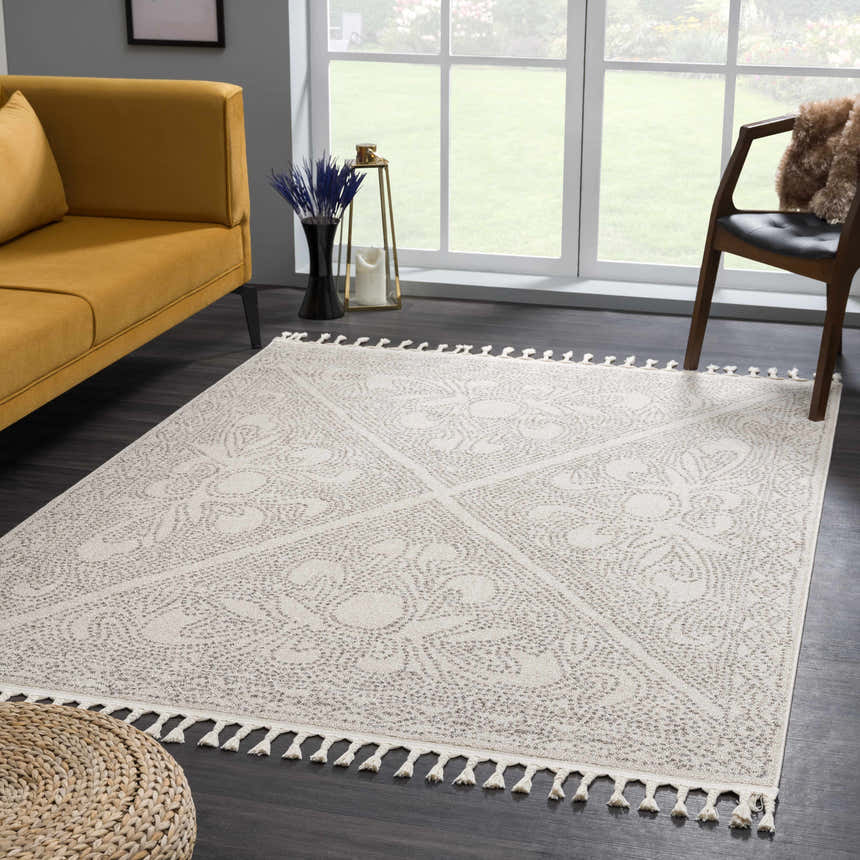 Living room scene with a Birdwood Cream & Brown Area Rug, mustard sofa, wood chair, and woven pouf. Roomscene-Rectangle