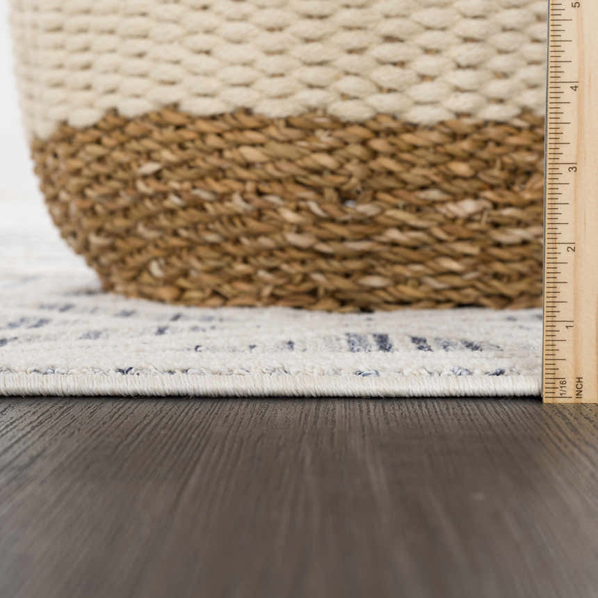 Close-up of the Magnolia Blue 2302 Area Rug showing cream and blue geometric pattern and texture, with a ruler for scale. Pile