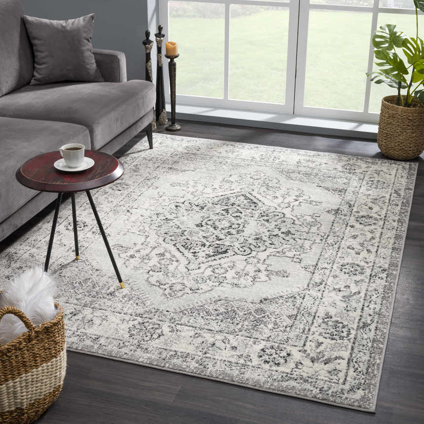 Living room scene with gray sofa and Marash KMRSH-4615 area rug in black, gray, and ivory. Bohemian style rug. Roomscene-Rectangle