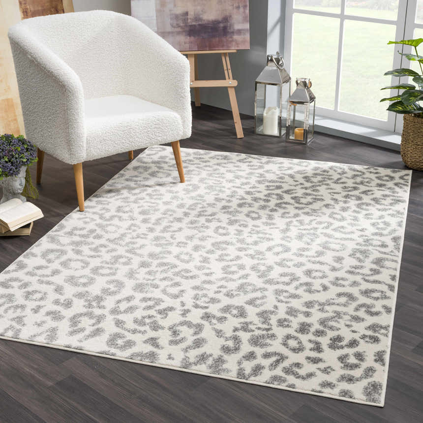 Living room scene with a white armchair and the gray and ivory Marash Leopard Print Area Rug. Roomscene-Rectangle