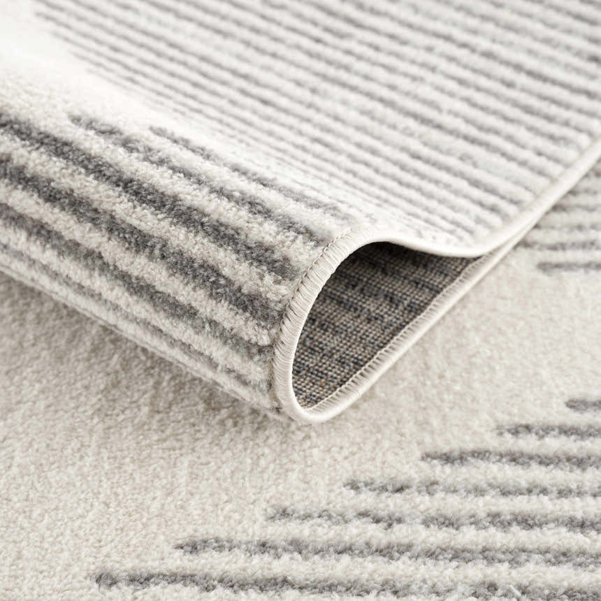 Close up of the Marash KMRSH-4613 area rug showing its gray and ivory geometric pattern and soft, textured pile. Fold