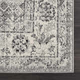 Close up of the black, gray, and ivory Marash KMRSH-4615 area rug showing its traditional pattern and soft texture. Corner