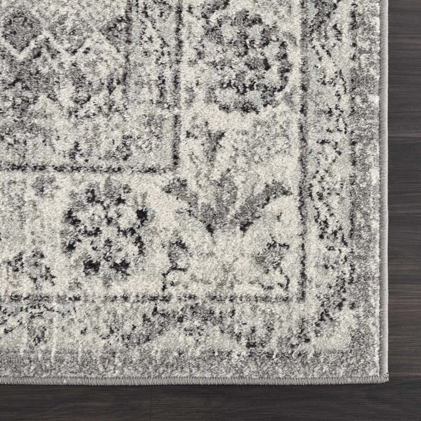 Close up of the black, gray, and ivory Marash KMRSH-4615 area rug showing its traditional pattern and soft texture. Corner