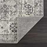 Close-up of the Marash KMRSH-4615 area rug showing its black, gray, and ivory bohemian pattern and machine-made construction. Fold