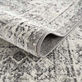 Close up of the Marash KMRSH-4615 area rug. Black, gray, and ivory tones with a subtle, abstract pattern and soft texture. Fold