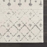 Close-up of the Marash KMRSH-4606 area rug. Cream rug with gray geometric and floral-inspired patterns. Polypropylene texture. Corner