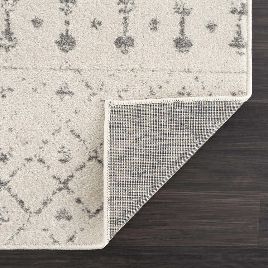 Close-up of the Marash KMRSH-4606 area rug featuring a cream and gray contemporary pattern and machine-made construction. Fold