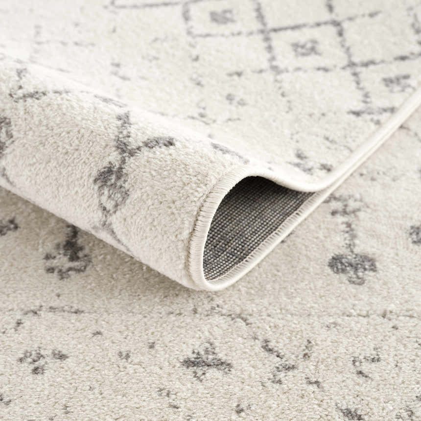 Close-up of the Marash KMRSH-4606 area rug showing the cream color and gray geometric pattern. Machine-made polypropylene texture. Fold
