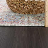 Close-up of the Cream Rust Leeston Washable Rug showing its brick red, light blue, and cream vintage pattern and texture. Pile