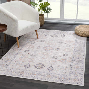 Living room scene with a Beige Beckett Washable Rug, white chair, and natural light. Bohemian style. Roomscene-Rectangle